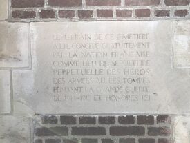 Pierre gravée enchâssée dans le mur d'enceinte ouest, visible depuis l'intérieur du cimetière.