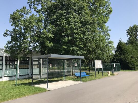 Entrée du groupe scolaire du côté de la rue du Mont Houy. Un enrobé a été réalisé sur le chemin d'accès, et un abri a été installé pour protéger parents et enfants en cas de pluie.